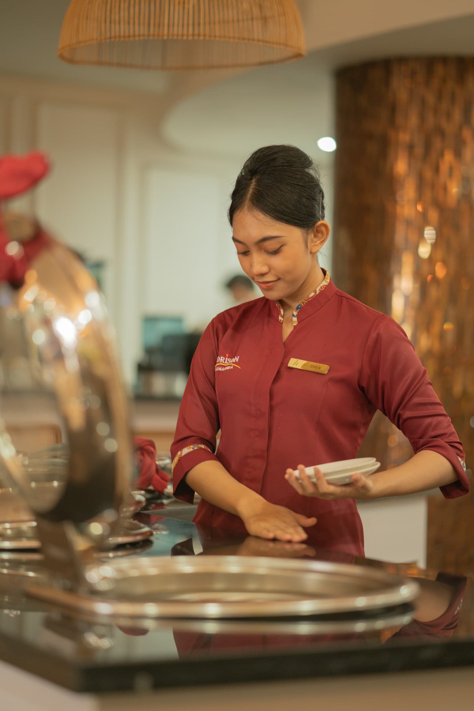A server in uniform arranging plates before service